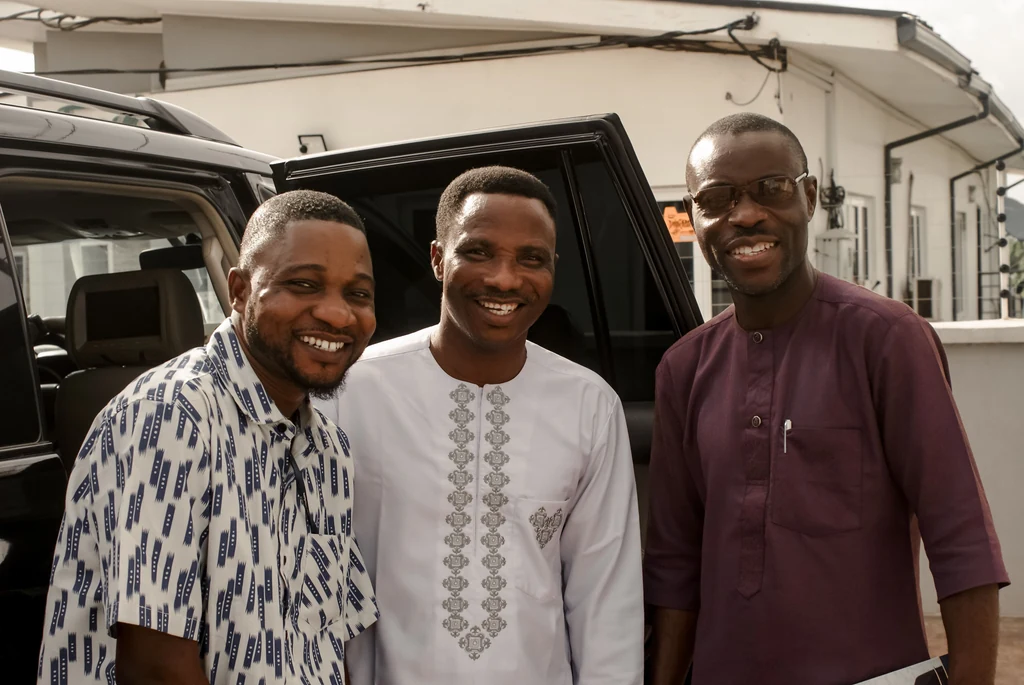 Three men smiling together outdoors