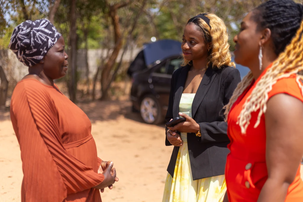 Three women talking together outdoors at a church gathering
